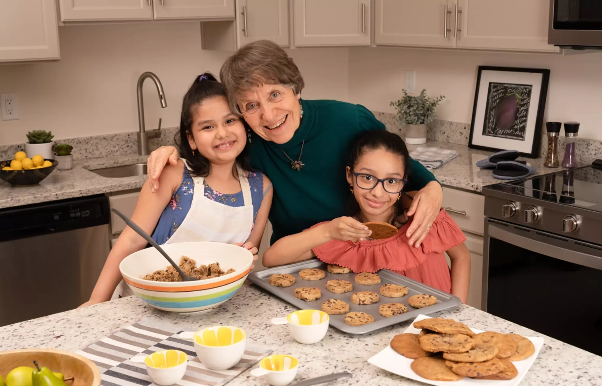 grandma baking cookies with two young girls